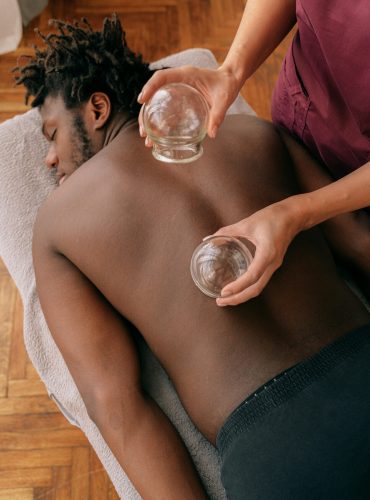 Man receiving traditional cupping therapy for relaxation and muscle tension relief.